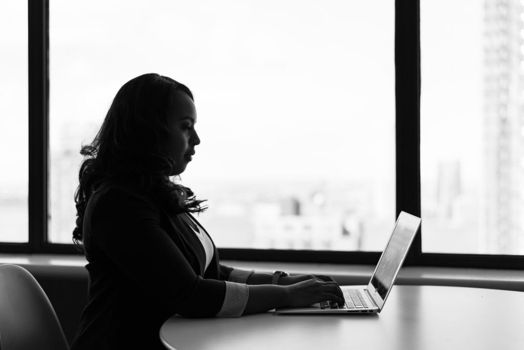 grayscale photography of woman using laptop